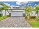 Two story house with white garage door and paver driveway at 1687 Kona Ln, Davenport, FL 33897
