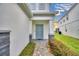 Light blue front door entry with gray stone and landscaping at 1687 Kona Ln, Davenport, FL 33897