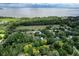 Aerial view of waterfront property with lush landscaping and nearby homes at 110 W Railway Ave, Oakland, FL 34760