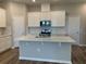 Modern kitchen with white cabinets, quartz countertops, and stainless steel appliances at 15102 Stuttgart Aly, Winter Garden, FL 34787