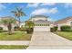 Two-story house with a two-car garage and palm trees at 145 Cork Way, Davenport, FL 33897
