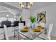 Bright dining room with glass table and modern chandelier at 145 Cork Way, Davenport, FL 33897
