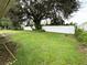 Fenced backyard with large tree and grassy area at 307 Colonade Ct, Kissimmee, FL 34758