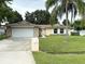 Single-story house with a stone facade, attached garage, and well-maintained lawn at 307 Colonade Ct, Kissimmee, FL 34758