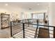 Open loft area overlooking main living space, featuring a modern staircase and railing at 547 Marcello Blvd, Kissimmee, FL 34746