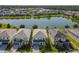Aerial view of a lakefront community with several houses and lush landscaping at 547 Marcello Blvd, Kissimmee, FL 34746