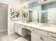 Double vanity bathroom with a large mirror and stylish artwork at 547 Marcello Blvd, Kissimmee, FL 34746