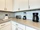 White kitchen cabinets, gray countertops, and modern appliances at 547 Marcello Blvd, Kissimmee, FL 34746