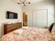 Bedroom with a floral comforter, TV, dresser and bathroom access at 547 Marcello Blvd, Kissimmee, FL 34746