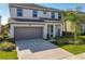 Two-story house with attached garage, landscaping, and a palm tree at 547 Marcello Blvd, Kissimmee, FL 34746