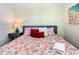 Bedroom with a floral comforter, bedside table, and yellow striped wall at 547 Marcello Blvd, Kissimmee, FL 34746