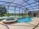 Inviting pool and spa with screened enclosure and lake view at 547 Marcello Blvd, Kissimmee, FL 34746