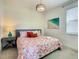Bedroom with a floral comforter, bedside table, and yellow striped wall at 547 Marcello Blvd, Kissimmee, FL 34746