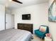 Bedroom with TV, dresser, comfy chair, and stylish decor at 547 Marcello Blvd, Kissimmee, FL 34746