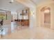 Elegant hallway with travertine floors and views into a modern kitchen at 5174 Vardon Dr, Windermere, FL 34786