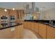 Modern kitchen with curved island, stainless steel appliances, and light wood cabinets at 5174 Vardon Dr, Windermere, FL 34786