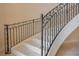 Elegant curved staircase with wrought iron railing and marble steps at 5174 Vardon Dr, Windermere, FL 34786