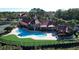 Community pool and clubhouse with red tile roofs, lush landscaping, and tennis court at 200 Afton Sq # 208, Altamonte Springs, FL 32714