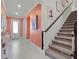 Bright entryway with staircase and coral-colored walls at 918 Savannah Palms Blvd, Orlando, FL 32828