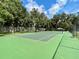 Green tennis court surrounded by trees at 70 Millholland St, Oakland, FL 34760