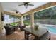 Covered patio with fire pit, comfortable seating and view of the pool at 70 Millholland St, Oakland, FL 34760