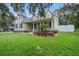 Two-story house with neutral siding, welcoming porch and lush landscaping at 70 Millholland St, Oakland, FL 34760