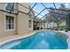 Curved pool with screened enclosure and plenty of lounge space at 70 Millholland St, Oakland, FL 34760