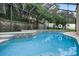 Inviting pool with tiled water features and screened enclosure at 70 Millholland St, Oakland, FL 34760
