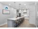 Modern kitchen island with seating, white cabinets, and stainless steel appliances at 70 Millholland St, Oakland, FL 34760