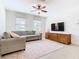 Bright living room featuring a cozy sectional sofa and a large TV at 8920 Dove Valley Way, Davenport, FL 33896
