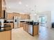 Modern kitchen with stainless steel appliances and light wood cabinets at 8920 Dove Valley Way, Davenport, FL 33896