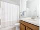 Clean bathroom with shower/tub combo, wood vanity, and striped curtain at 8920 Dove Valley Way, Davenport, FL 33896