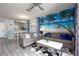 Bright living room features comfortable seating, a coffee table, and a unique wall mural at 3052 Secret Lake Dr, Kissimmee, FL 34747