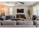 Spacious living room with sectional sofa, large TV, and a ceiling fan at 9102 Sommerset Hills Dr, Davenport, FL 33896