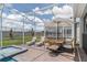 Screened patio with pool, spa, lounge chairs, and dining area at 9102 Sommerset Hills Dr, Davenport, FL 33896