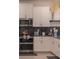 Modern kitchen with white cabinets and dark tile backsplash at 9102 Sommerset Hills Dr, Davenport, FL 33896