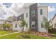 Two-story modern home with gray and white exterior and landscaping at 9102 Sommerset Hills Dr, Davenport, FL 33896