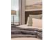 Cozy bedroom with a wood headboard, soft pillows, and a gray throw blanket at 9102 Sommerset Hills Dr, Davenport, FL 33896