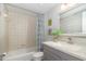 Bathroom with tub, gray vanity, and beach-themed decor at 2100 Ocean Shore Blvd # 203, Ormond Beach, FL 32176