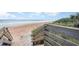 Wooden staircase leads to a beautiful beach with ocean view at 2100 Ocean Shore Blvd # 203, Ormond Beach, FL 32176