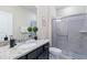 Bathroom with granite countertop, dark vanity, and shower at 710 Gardenia Ln, Davenport, FL 33897