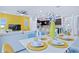 Modern dining area with white table, yellow accents, and a view of the living room at 710 Gardenia Ln, Davenport, FL 33897
