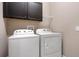 Laundry room with washer, dryer, and overhead cabinets at 1577 Castile St, Celebration, FL 34747