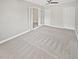 Spacious bedroom with neutral carpeting, French doors, and ample closet space at 702 Sullivan Ave, Ocoee, FL 34761