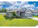 Gray house with a two-car garage and landscaping at 220 Bergamot Loop, Davenport, FL 33837