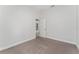 Simple bedroom with neutral-toned carpet and an open doorway at 220 Bergamot Loop, Davenport, FL 33837