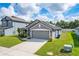 Gray house with a two-car garage and landscaping at 220 Bergamot Loop, Davenport, FL 33837