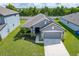 Gray house with a two-car garage and solar panels at 220 Bergamot Loop, Davenport, FL 33837