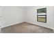 Simple bedroom with neutral walls, carpeting, and a window at 220 Bergamot Loop, Davenport, FL 33837