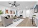 Spacious living room with comfortable seating, large windows, and ceiling fan at 1603 Woodlyn Dr, Leesburg, FL 34748
